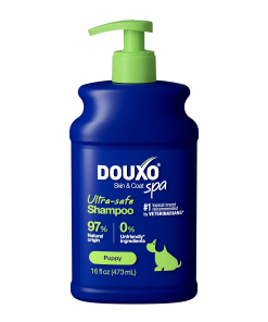 The front of a 16 fl oz bottle of DOUXO Puppy Ultra-safe Shampoo for dogs, featuring a dark blue bottle with a light green pump dispenser and green label accents.